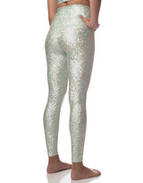 woman wearing sneaker length legging with mermaid pattern of mint colored sparkling fish scales on grey background