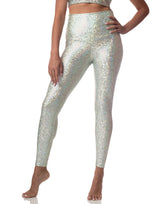 woman wearing sneaker length legging with mermaid pattern of mint colored sparkling fish scales on grey background