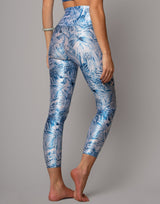 Person wearing blue floral leggings on a gray background