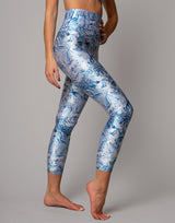 Person wearing blue and white patterned leggings on a gray background
