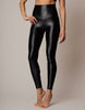 Person wearing shiny black leggings on a neutral background