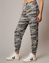 Camouflage jogger pants worn by a person on a plain background