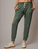 Green jogger pants worn by a person on a plain background