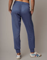 Person wearing blue sweatpants with a neutral background