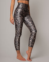 Person wearing black and white patterned leggings on a gray background