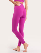 A model wearing bright magenta high-waisted leggings and a matching sports bra, shown from the waist down against a plain light background.