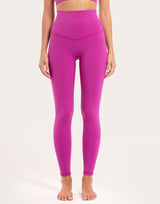 A model wearing bright magenta high-waisted leggings and a matching sports bra against a plain light background.