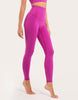 A model wearing high-waisted magenta pink leggings and a matching sports bra, shown from the waist down against a plain white studio background.