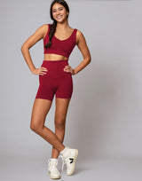 Person wearing red high-waisted shorts on a plain background