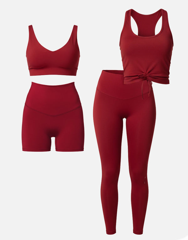 Red athletic outfit with sports bra, shorts, and leggings on a white background