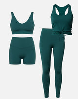 Green athletic outfit with sports bra, shorts, and leggings on a white background