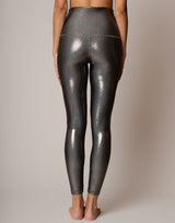 Person wearing shiny silver leggings on a plain background