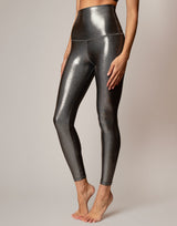 Shiny silver leggings worn by a person on a neutral background