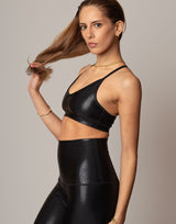 Woman wearing a black shimmer outfit against a neutral background