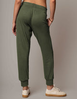 Person wearing green sweatpants on a plain background