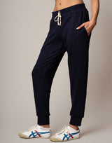 Navy jogger pants worn by a person on a plain background