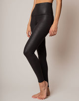 Person wearing black leggings on a plain background