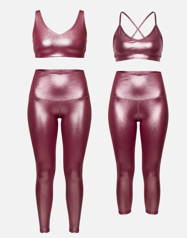 Maroon shiny sports bra and leggings set on a white background