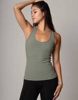 Woman wearing a green tank top against a gray background