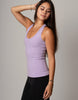 Woman wearing a purple tank top against a gray background