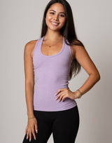 Woman wearing a purple tank top and black leggings against a plain background