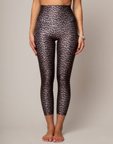 Person wearing leopard print leggings on a plain background