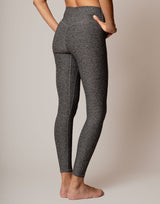 Dark gray leggings worn by a person on a plain background