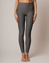 Person wearing gray leggings on a plain background