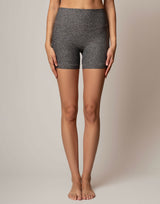 Person wearing gray shorts on a beige background