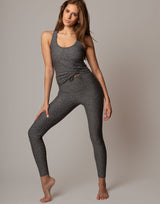 Woman wearing a gray athletic outfit on a plain background