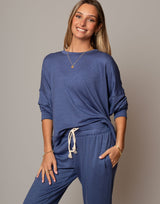 Woman wearing a blue outfit with a plain background