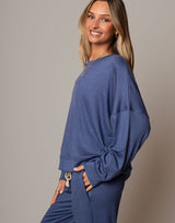 Woman wearing a blue outfit against a gray background