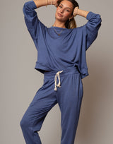 Woman wearing a blue outfit with a beige background
