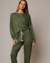 Woman wearing a green loungewear set against a plain background