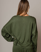 Green long-sleeve top worn by a person on a neutral background