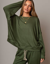 Woman wearing a green outfit with a plain background