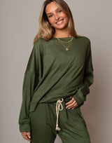 Woman wearing a green outfit with a plain background