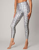 Person wearing silver snake print leggings on a gray background