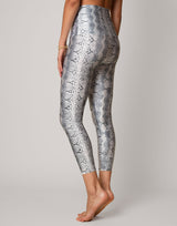 Silver snake print leggings worn by a person on a gray background