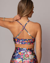 Woman wearing a colorful floral outfit with a neutral background