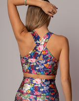 Woman wearing a colorful floral two-piece outfit against a neutral background