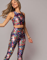Woman wearing a floral sports bra and leggings set on a gray background