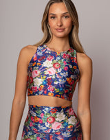 Woman wearing a colorful floral outfit against a plain background